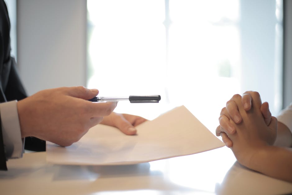 Image description: An image showing a person filling out a job application form on a desk.